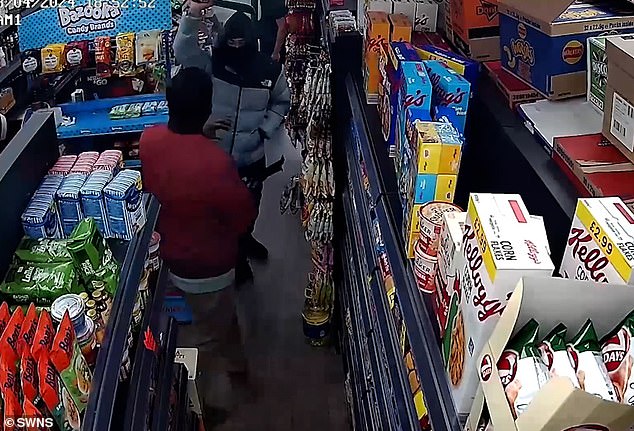 The thief threatens the shopkeeper with his machete before the quick-witted clerk locks him inside.