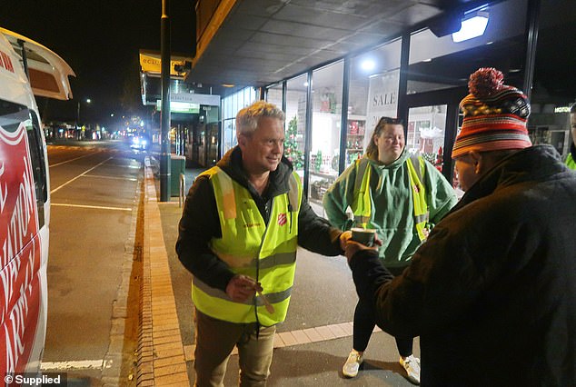 Channel 7 star Nathan Templeton hands a hot drink to a homeless man on the streets of Geelong.