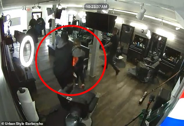 A New Jersey barber was caught on camera carrying a child to safety and picking him up in his arms mid-cut.