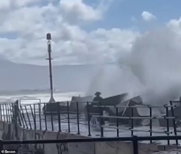 Heartwarming footage has emerged of a father bravely diving into turbulent waters to save his young daughter who had been swept away by a large wave (pictured).