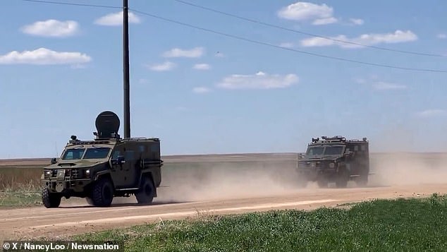 A massive convoy of SWAT trucks and police cars rolls through rural Oklahoma on Saturday. Authorities announced the arrests shortly after.