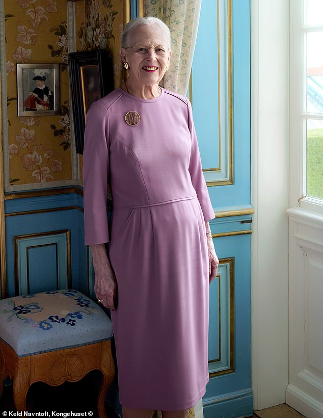 Queen Margaret poses in one of the rooms at Fredensborg Castle, leaning against the beautifully decorated teal walls.