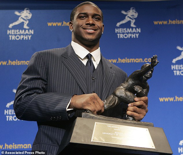 USC's Reggie Bush smiles with the Heisman Trophy during a press conference in 2005
