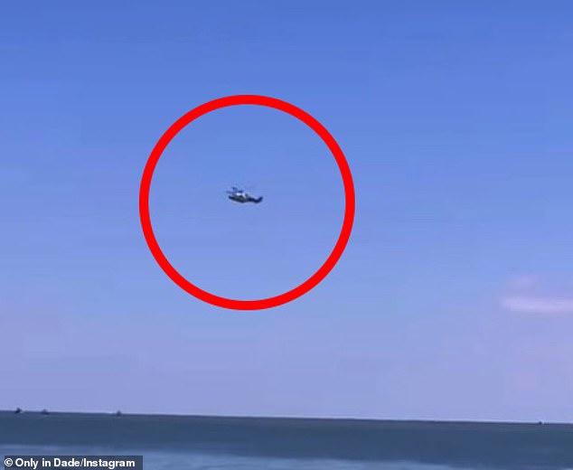 Emergency officials rushed to the pilot's aid as frightened onlookers watched the rescue unfold;  In the photo: a rescue helicopter flying over the pilot in distress.
