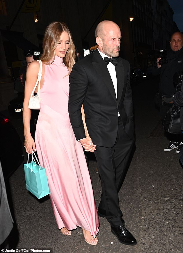 Acting like the gentleman he truly is, Jason, 56, held Rosie's hand as he led them to the venue.  He looked dapper in a fabulous two-piece black tuxedo paired with a black bow.