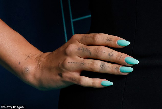 Gen Z celebrities like Hailey Bieber, 27, love small, delicate designs on their hands, as seen above.