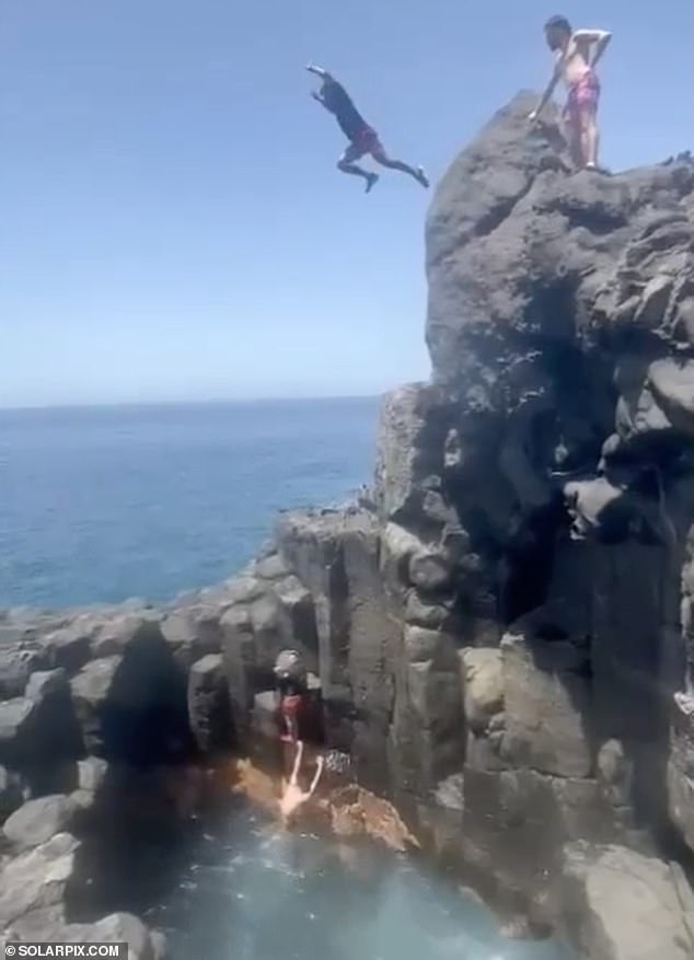 A group of men, supposedly friends of the tourist, counted from five before jumping into the air.