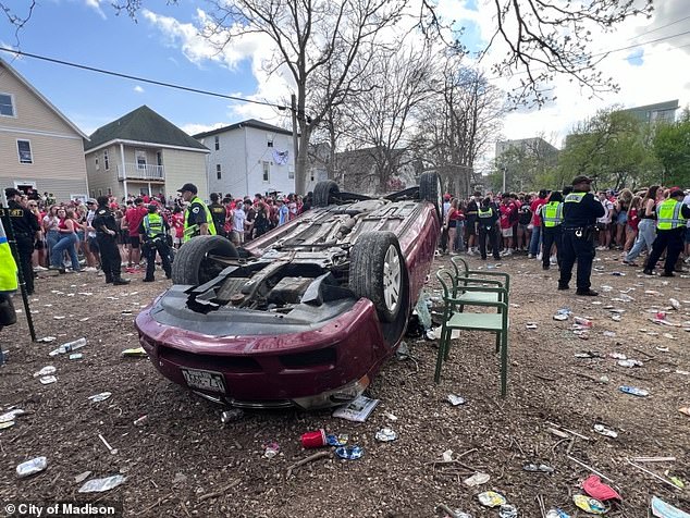 Some attendees flipped over a red Dodge Avenger, which belongs to Reigna Jackson, who said the lack of support from the university was 'infuriating' as she asked for donations to replace her vehicle, which has been written off.