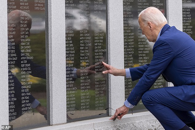 President Joe Biden touches the name of his uncle Ambrose J. Finnegan, Jr., on a wall of a Scranton war memorial, Wednesday, April 17, 2024, in Scranton, Pennsylvania.  His uncle died in World War II.