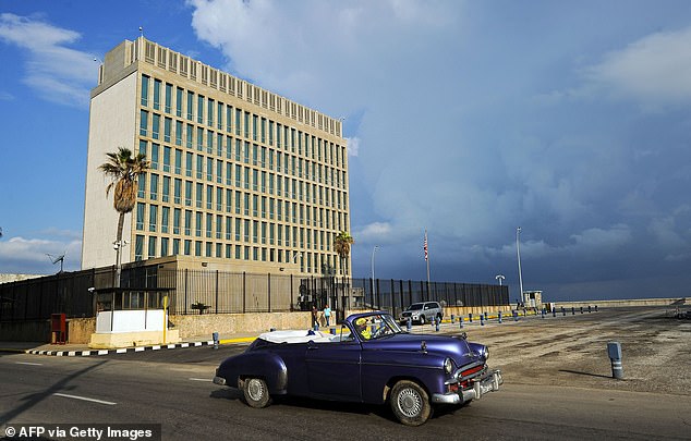 Above, an old American car passes the US embassy in Havana on December 17, 2015.