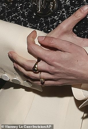 She wore a gold ring on her engagement finger.