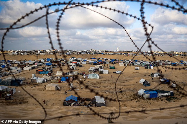 Tents housing displaced Palestinians are shown behind barbed wire in Rafah in the southern Gaza Strip on Tuesday.  Palestinians with ties to the United States would be vetted, but would then have access to housing benefits and a path to American citizenship.