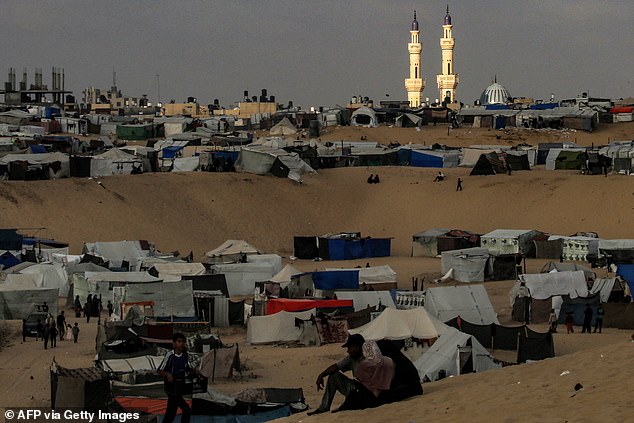 Light illuminates the minarets of the al-Taiba mosque at dusk before the tents of displaced Palestinians in a camp in Rafah, southern Gaza Strip, on Tuesday.
