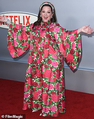 Melissa was radiant and flashed a cheerful smile at the event as she donned a long-sleeved floral-print dress that contained shades of pink, red, and also green.
