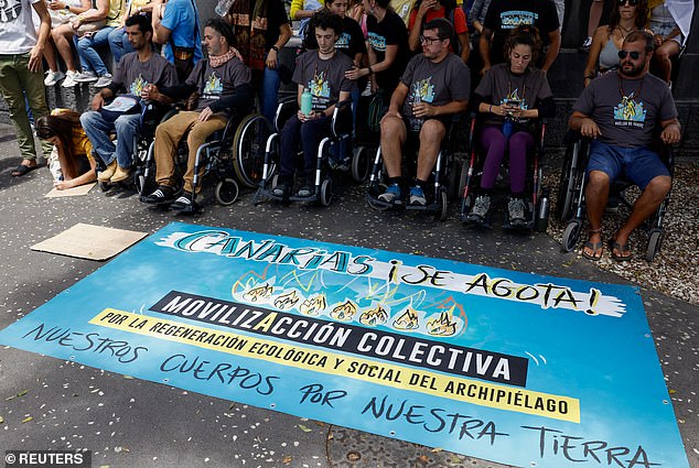 Hunger strikers sit in wheelchairs during a demonstration for a change in the tourism model in the Canary Islands, in Santa Cruz de Tenerife, Spain, on April 20, 2024.