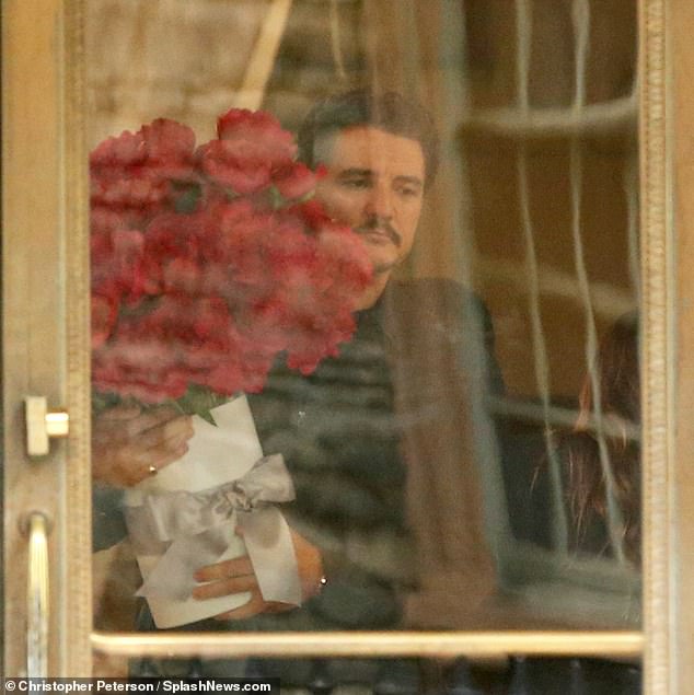 The 34-year-old actress beamed from ear to ear as she accepted the huge bouquet of flowers from the 49-year-old actor on the New York set of their film Materialists.