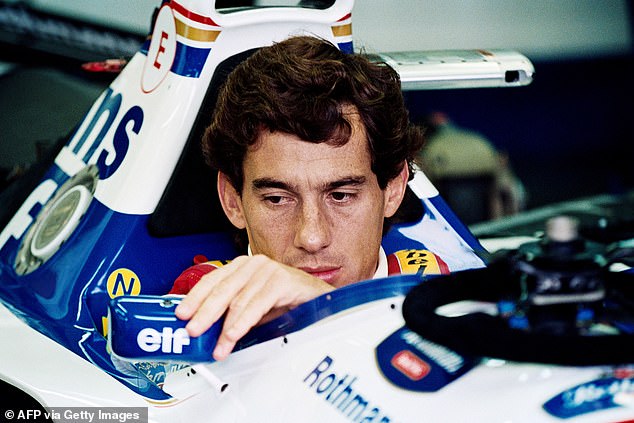 Senna adjusts his rearview mirror in the pits before the 1994 San Marino Grand Prix