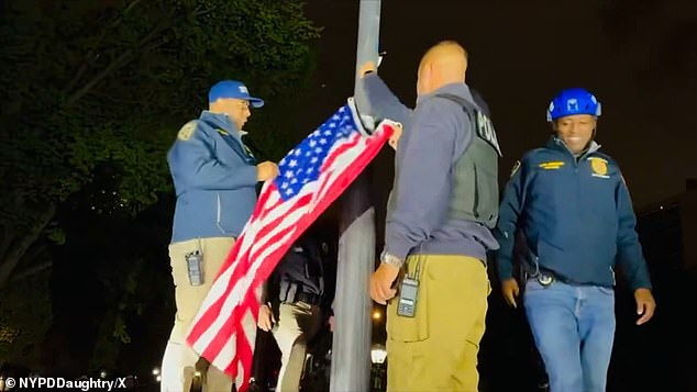 Footage taken on the ground shows an officer tossing the flag aside before raising Old Glory on the flagpole.