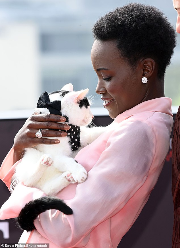 The actress, 41, looked in good spirits as she hugged the feline while posing at the IET London: Savoy Place on Wednesday.