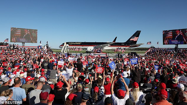 Donald Trump flew to Michigan for a rally at an airfield where his plane stopped before a spirited crowd of supporters.