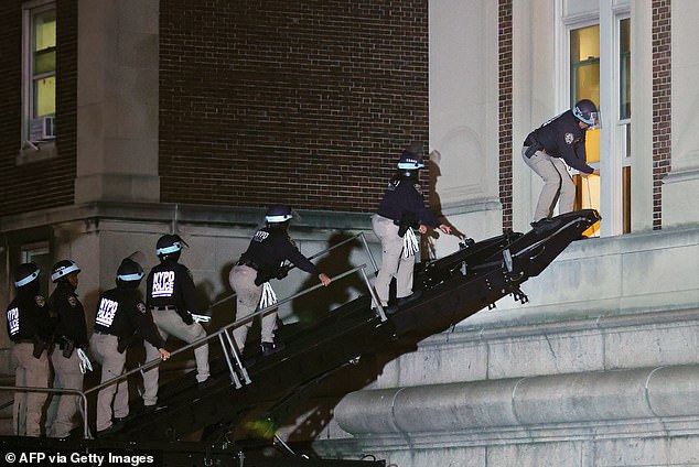 NYPD police officers dressed in riot gear burst through a window of a Columbia University building occupied by dozens of pro-Palestinian protesters to begin clearing them out.