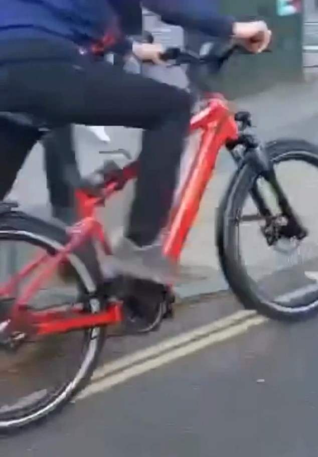 The man then pulls the bike off the railing through the gap he made and walks away.