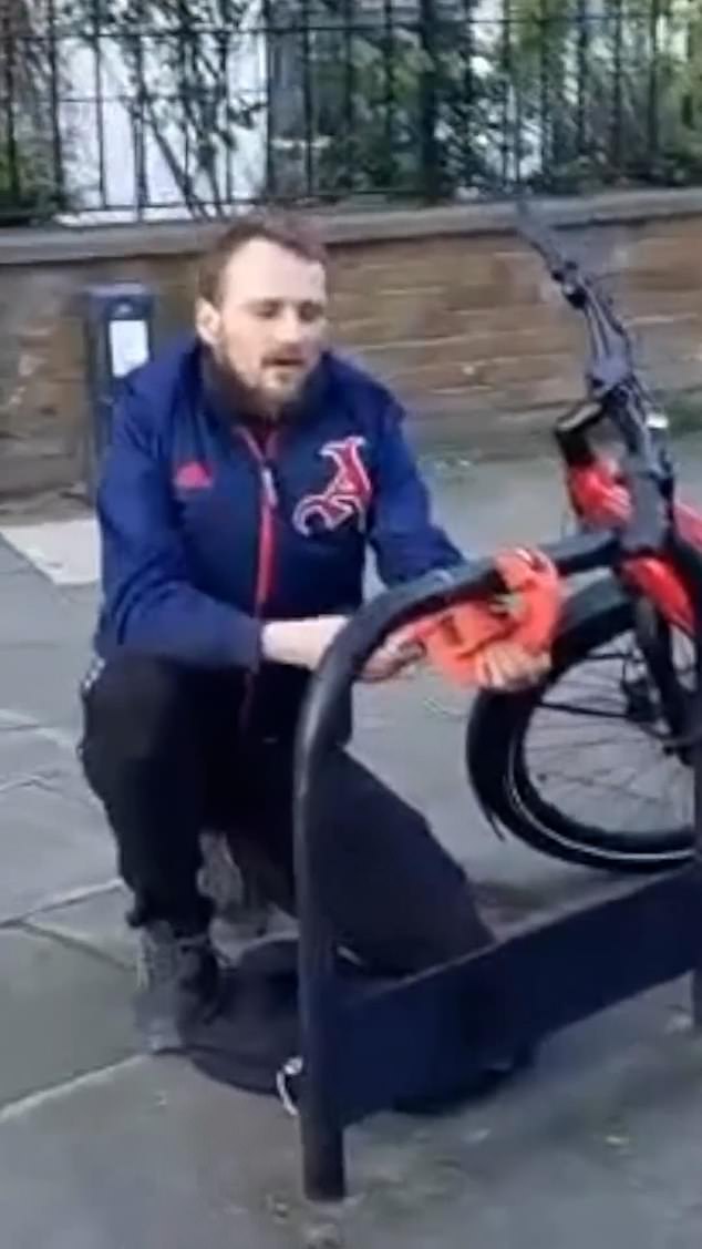 A video shows a man in north London holding a pipe cutter close to a metal bicycle railing.