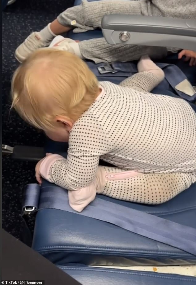 The one-year-old is seen struggling to get up from the seat and therefore squirms restlessly.