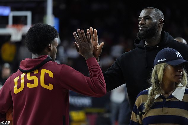 Young James, left, high-fives his father before a game against Stanford in Los Angeles in January.
