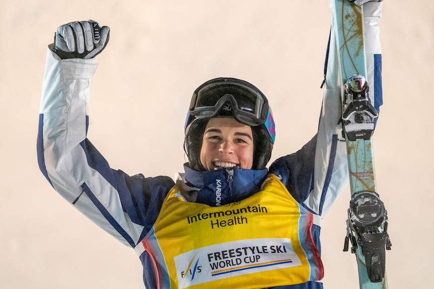 Jakara Anthony lifts his skis and smiles