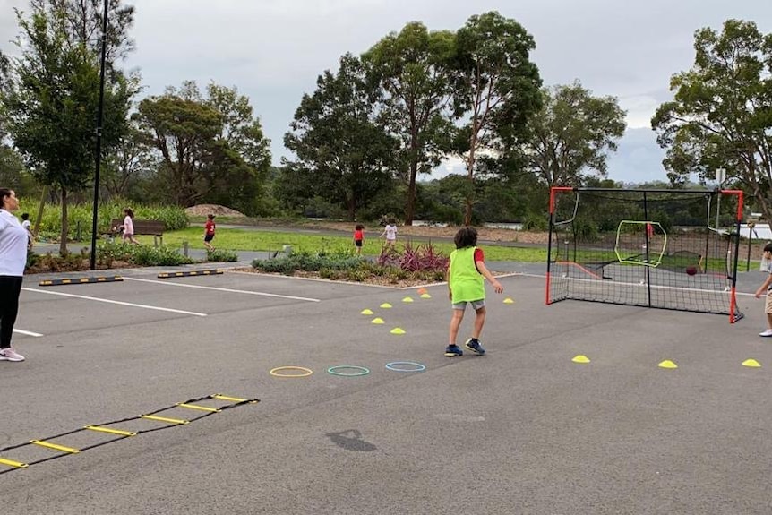 A trainer with sports exercises and cones installed in a parking lot.