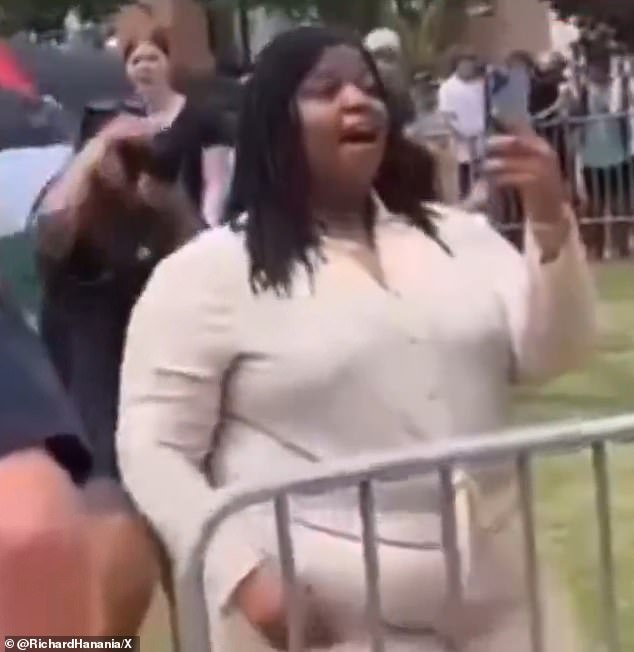 The protester stood her ground and filmed the barking crowd as they shouted insults about her weight.