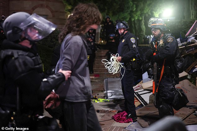 The confrontation was the latest example of unrest following demonstrations of solidarity with Gaza on campuses.  Pictured: California Highway Patrol (CHP) officers detain a protester while clearing a pro-Palestinian encampment after dispersal orders were given at UCLA on May 2, 2024.
