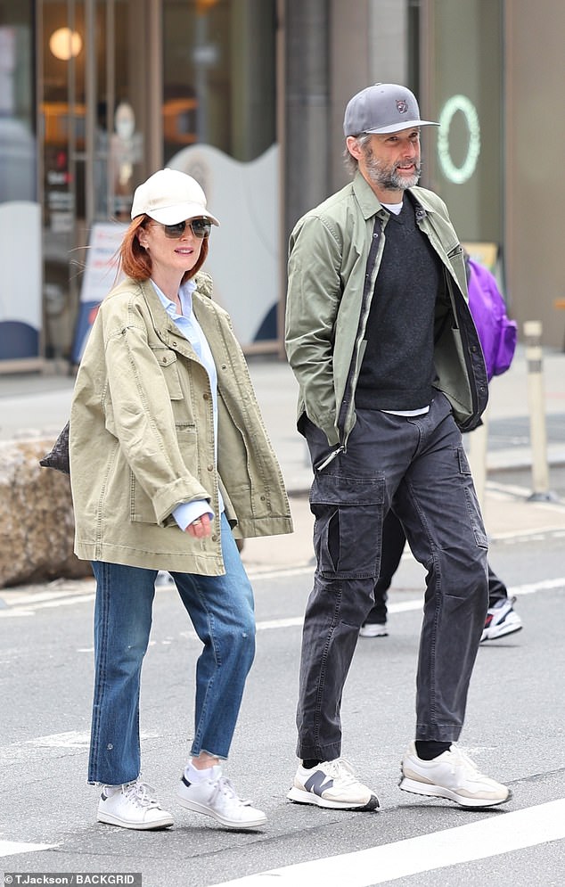 Moore stepped out in blue jeans with a light brown cargo jacket over a light blue dress shirt and white sneakers, while her husband sported a similar look in black cargo pants, a light green jacket, and baseball caps.