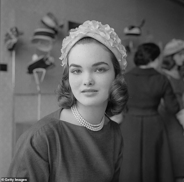 Henrietta Tiarks (later Henrietta Russell, Marchioness of Tavistock and Duchess of Bedford) models a hat in a hat shop in 1957