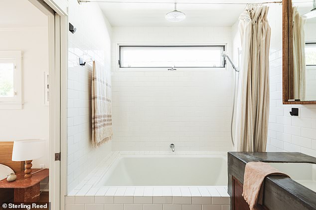 It is connected to a private bathroom with a custom vanity and spa-style tub.