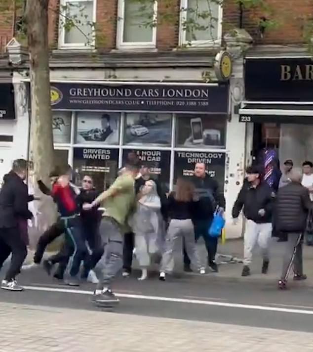 Met police officers battle to contain the violence which spread to the road and oncoming traffic.