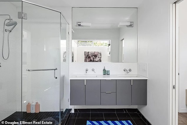 Each of the bathrooms is modern and stylish, with dark floors, white walls, and glass showers.