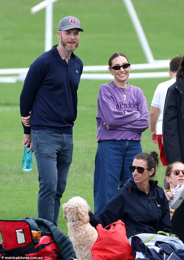 The loved-up couple were all smiles as they cheered on the nine-year-old as he ran up and down the sports field.