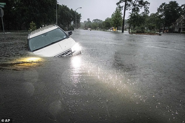 A pickup truck is seen almost completely submerged in flood water Thursday in Spring, Texas.