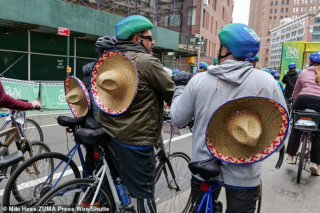 Three cyclists wore hats on their backs while participating in the Five Boro Bike Tour in New York City on Sunday.