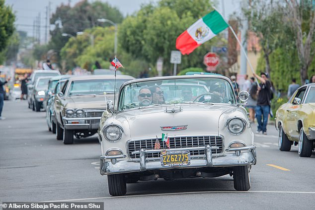 A variety of classic cars were displayed to the crowd while Mexican flags hung from the vehicles.