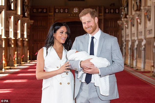 Meghan and Harry smile as they show off their newborn son to the world at St George's Hall at Windsor Castle.