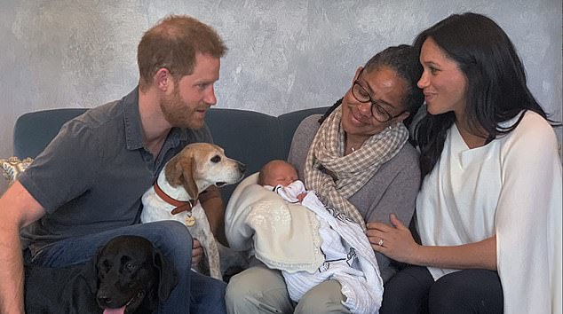 Baby Archie seen in the arms of his grandmother Doria Ragland as she sits next to Meghan and Harry at Frogmore Cottage