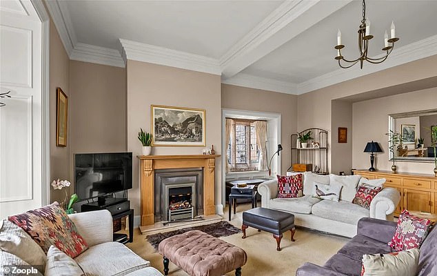 The main penthouse living room has high ceilings and a large fireplace, with plenty of seating space.