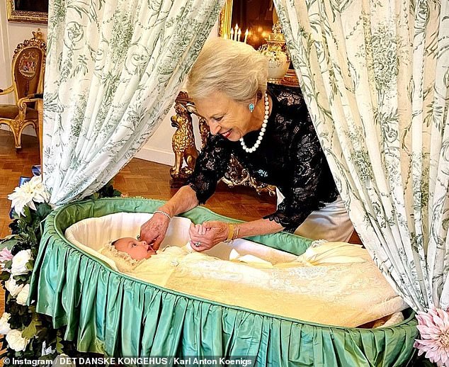 Another sweet photo shows Princess Benedikte admiring her grandson in a crib while lovingly pinching his cheek at last year's christening.