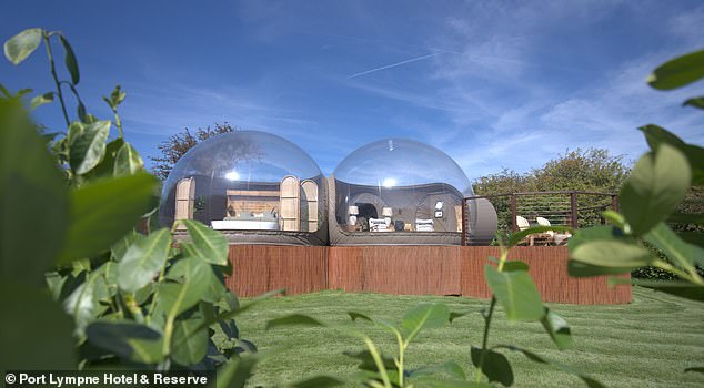 The transparent dome is luxuriously equipped with a large bed covered with cozy blankets.