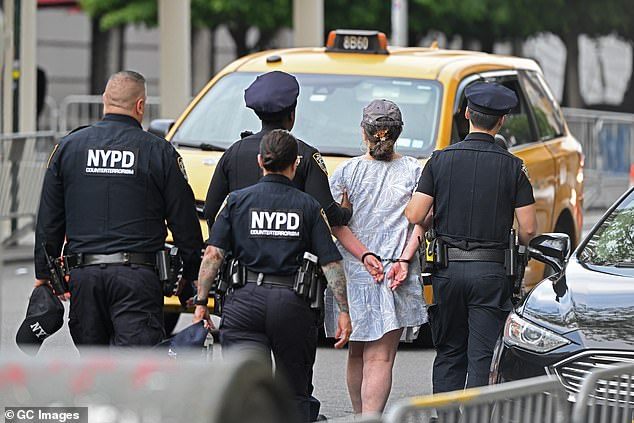 Officers take a person in handcuffs away from the 2024 Met Gala on Monday night