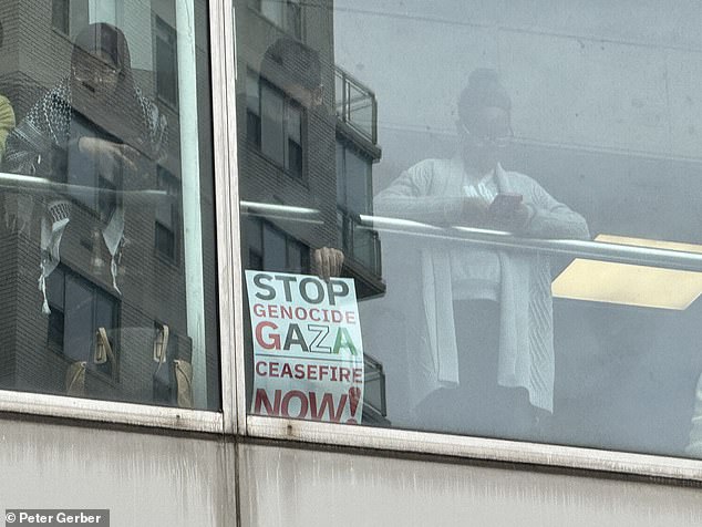 Students could be seen holding up signs from inside Hunter College.