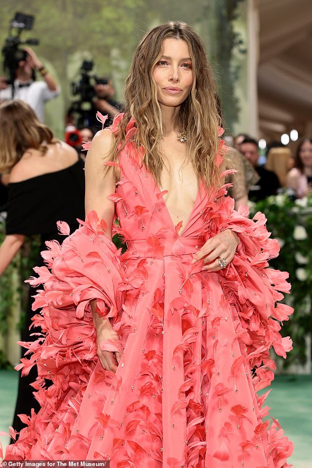 The actress, 42, who hit the carpet without her touring husband, Justin Timberlake, 43, wore no bra underneath the hot pink dress studded with dramatic feathers.